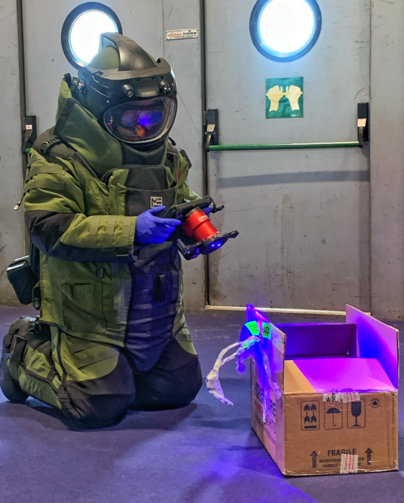 Crime-lite AUTO user in full hazmat CBRN suit examines forensic evidence 